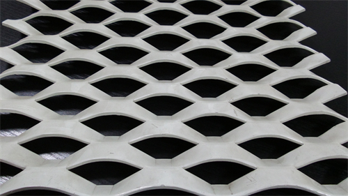 Expanded metal mesh starts as solid sheet of metal which is then simultaneously slit and stretched along its length.